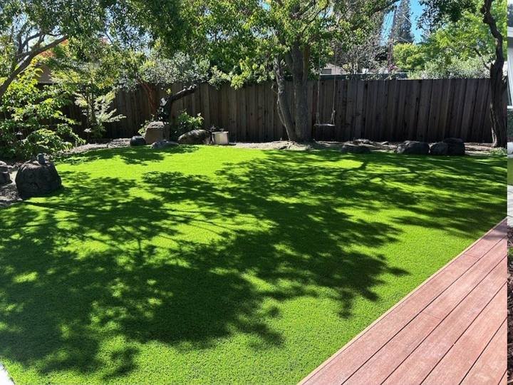 Finished backyard with new lawn beside a deck by DG Landscape Design